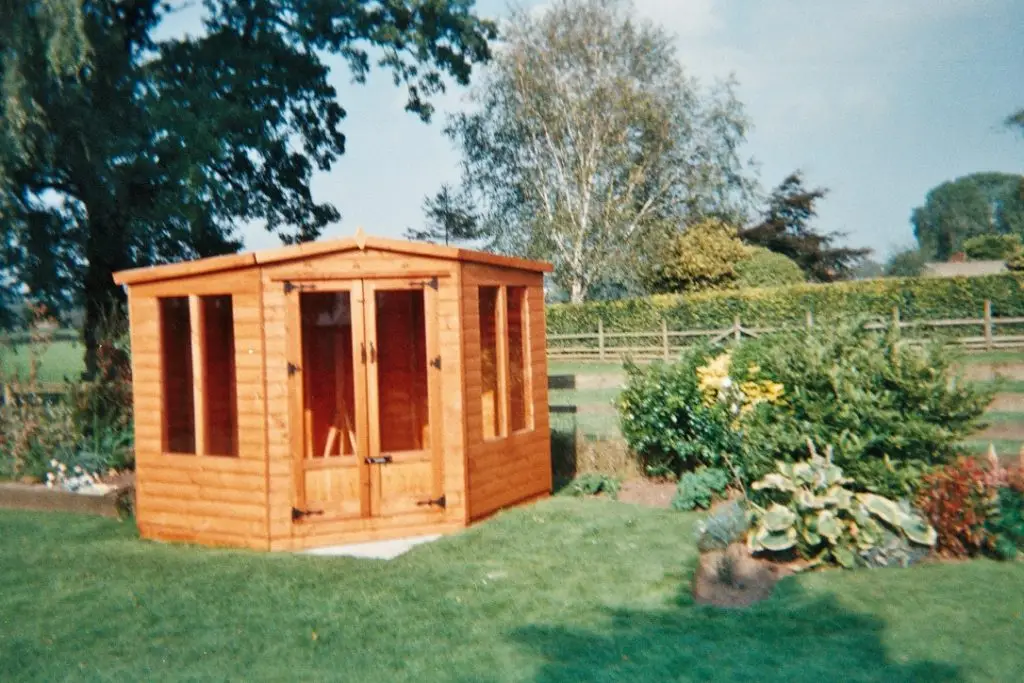CORNER SUMMERHOUSE SHOWN IN CEDAR COLOUR BY LANCASHIRE SUMMERHOUSES